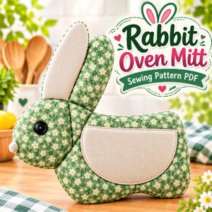 May include: A green oven mitt shaped like a rabbit with a white daisy floral pattern, a black button eye, a small round nose, and a beige pocket. The text Rabbit Oven Mitt Sewing Pattern PDF is displayed in a decorative graphic above the mitt.