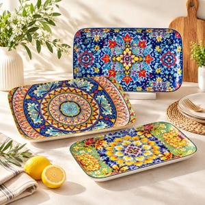 May include: Three rectangular ceramic serving platters featuring vibrant, multi-colored floral and geometric patterns. The designs include intricate mandalas and botanical motifs in shades of deep blue, bright yellow, red, and turquoise.