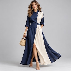 May include: A long-sleeved maxi dress featuring a color-blocked design with one side in deep navy blue and the other in cream. The dress has a wrap-style front with a button closure at the waist and a high side slit, paired with a small woven handbag.