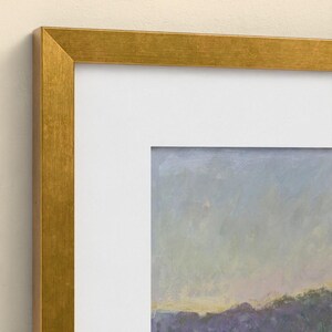 May include: A framed landscape painting featuring a textured gold frame and a wide white mat board. The artwork displays a soft, impressionistic sky in shades of pale blue and lavender above a dark, muted purple horizon line.