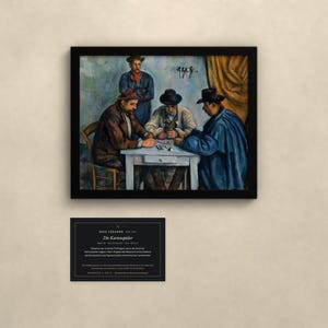 May include: A framed print of Paul C&eacute;zanne's painting The Card Players, depicting three men playing cards at a table with a fourth man standing behind them. Below the frame is a black informational plaque with white text detailing the artwork.