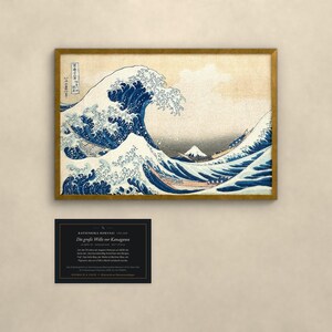 May include: A framed print of The Great Wave off Kanagawa by Katsushika Hokusai, featuring a large blue wave, white foam, and Mount Fuji in the distance. Below the print is a black rectangular information card with white text.