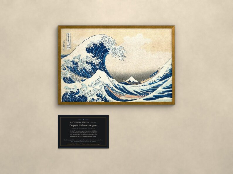 May include: A framed print of The Great Wave off Kanagawa by Katsushika Hokusai, featuring a large blue wave, white foam, and Mount Fuji in the distance. Below the print is a black rectangular information card with white text.