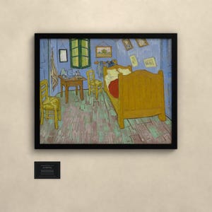 May include: A framed print of Vincent van Gogh's Bedroom in Arles painting, featuring a yellow bed, two wooden chairs, a small table, and blue walls, displayed with a small black informational plaque below the artwork.