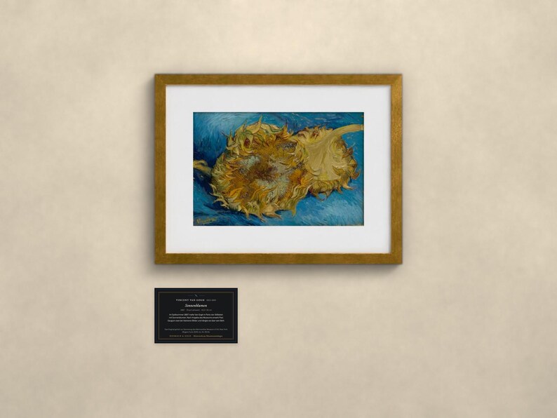 May include: A framed art print featuring two yellow sunflowers against a textured blue background, enclosed in a gold-toned frame with a white mat. Below the frame is a small black rectangular plaque with white text detailing the artwork.