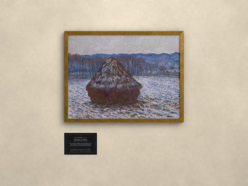 May include: A framed print of Claude Monet's Haystacks in Winter, featuring a dark brown haystack in a snowy field with blue-toned trees and mountains in the background. Below the artwork is a small black informational plaque with white text.
