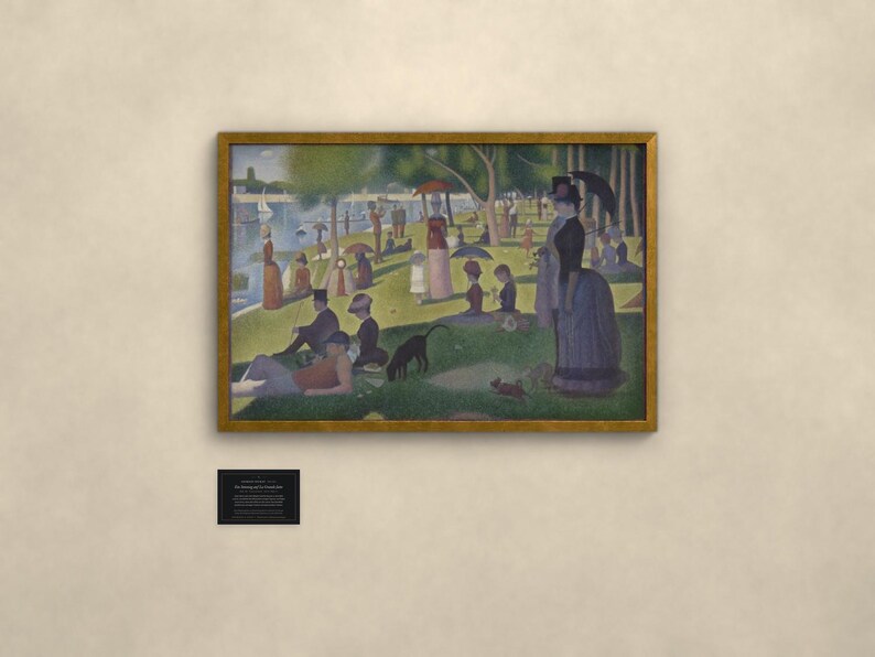 May include: A framed print of Georges Seurat's A Sunday Afternoon on the Island of La Grande Jatte, featuring a pointillist park scene with figures, trees, and a river. Below the frame is a small black plaque with white text detailing the artwork.