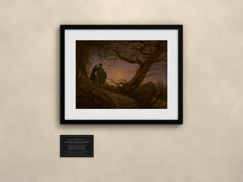 May include: A framed art print featuring the painting Two Men Contemplating the Moon by Caspar David Friedrich. The image shows two figures standing on a rocky path under a gnarled tree, looking at a crescent moon in a dark, twilight sky.