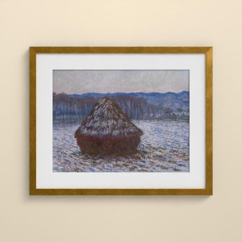 May include: A framed painting depicting a dark brown haystack centered in a snow-covered field. The background features a line of bare trees and distant blue hills under a pale sky. The artwork is enclosed in a metallic gold frame with a white mat.