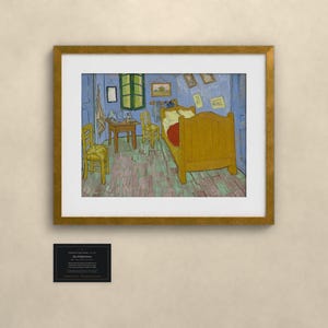 Pu&ograve; includere: Una stampa d'arte incorniciata della Camera di Van Gogh ad Arles, con un letto giallo, sedie in legno e un tavolo in una stanza blu. Sotto la stampa si trova una piccola targa nera con testo bianco che descrive l'opera e l'artista.
