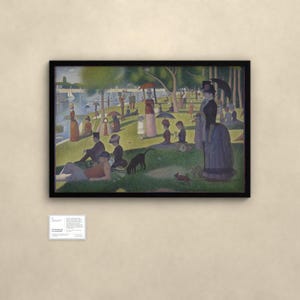 May include: A framed pointillist painting depicting a park scene with numerous figures, a dog, and a monkey on a grassy riverbank. The artwork features a black frame and is accompanied by a small white informational plaque mounted below it.