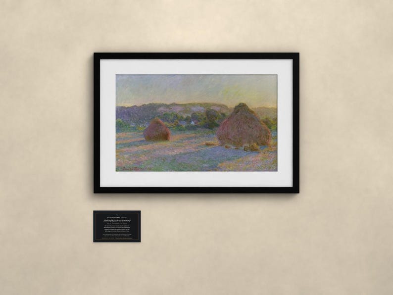 May include: A framed landscape painting depicting two haystacks in a field under a soft sky, featuring muted tones of purple, yellow, and green. Below the artwork, a small black rectangular plaque displays white text details.