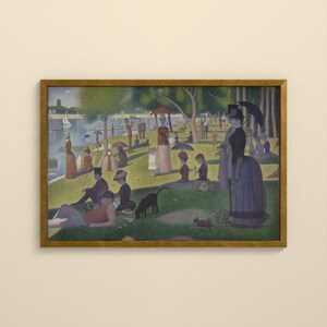 May include: A framed print of a pointillist painting depicting a park scene by a river. Numerous figures in period clothing are scattered across a green lawn, some holding umbrellas or parasols. A black dog stands near the center foreground.