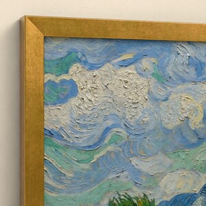 May include: A framed oil painting featuring thick, textured impasto brushstrokes in shades of light blue, white, and seafoam green. The artwork is encased in a metallic gold frame with a flat, smooth finish and sharp, angled corners.