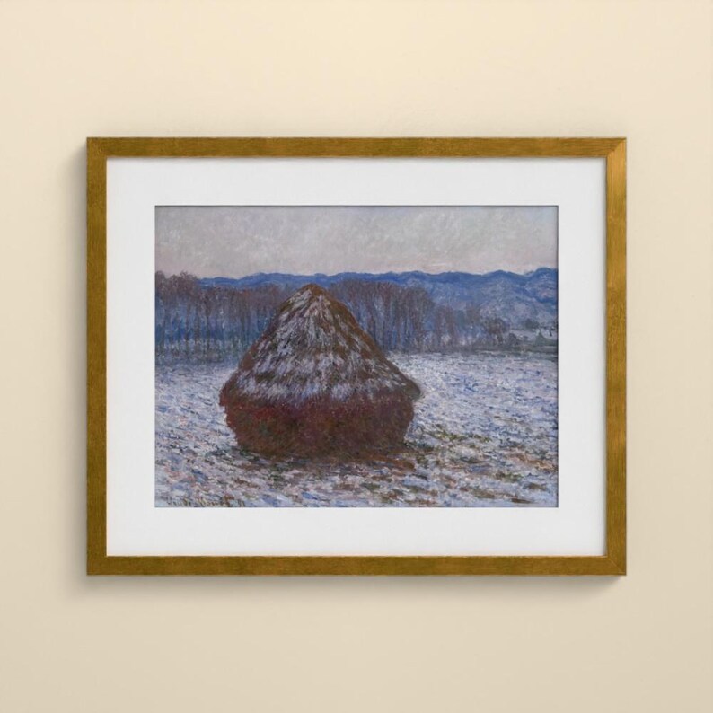 May include: A framed painting depicting a dark brown haystack centered in a snow-covered field. The background features a line of bare trees and distant blue hills under a pale sky. The artwork is enclosed in a metallic gold frame with a white mat.