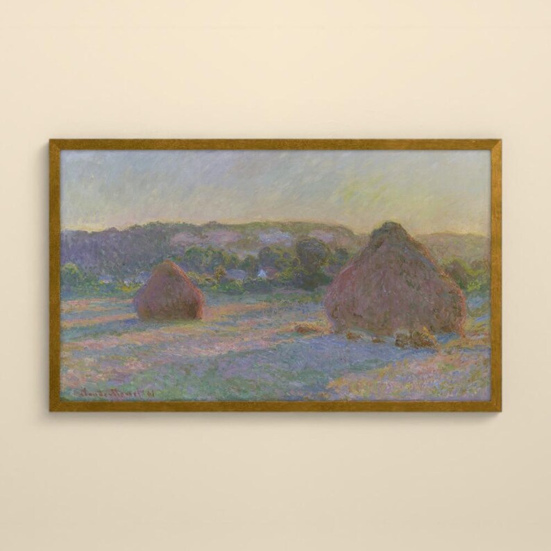 May include: A rectangular framed landscape painting depicting two large haystacks in a field at sunset. The scene features soft brushstrokes in shades of purple, blue, yellow, and green, with a distant treeline under a pale, hazy sky.