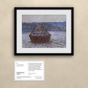 May include: A framed print of Claude Monet's painting titled Heuhaufen im Winter, depicting a dark haystack in a snowy field with blue-toned trees in the background. Below the frame is an informational card with text about the artwork.
