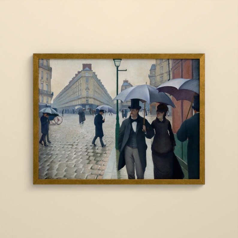 May include: A framed oil painting depicting a rainy Paris street scene with cobblestones and tall buildings. Several figures walk with dark umbrellas, including a central pair in formal attire, a man in a top hat and coat, and a woman in a dark dress.