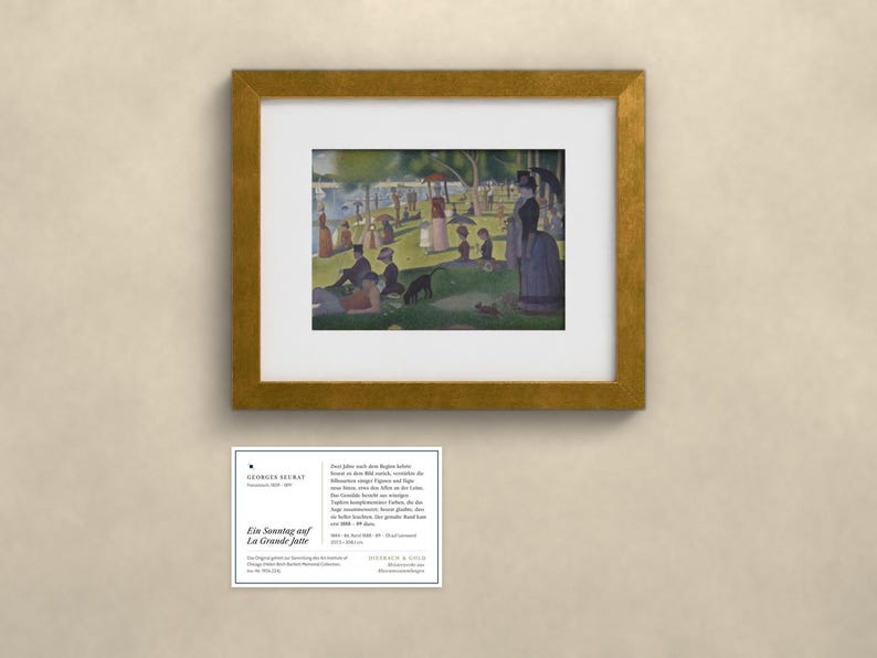 May include: A framed print of Georges Seurat's painting A Sunday on La Grande Jatte, featuring figures in a park by the water. Below the gold-framed artwork is a white informational card with the text Georges Seurat, Ein Sonntag auf La Grande Jatte.
