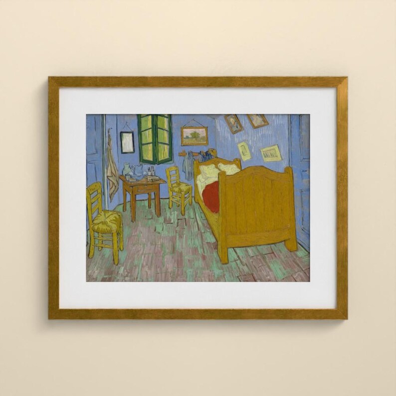 May include: A framed print of a painting depicting a bedroom with blue walls and a wooden floor. The room contains a large yellow bed, two yellow wooden chairs, a small wooden table, and several small framed pictures hanging on the walls.