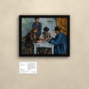 May include: A framed print of Paul C&eacute;zanne's The Card Players, depicting three men seated at a white table playing cards, with a fourth man standing behind them. The artwork features muted tones of blue, brown, and tan within a black frame.