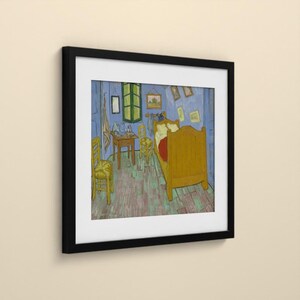 May include: A framed art print depicting a bedroom scene with a wooden bed, two chairs, and a small table. The walls are blue, the floor is light green, and the furniture is yellow. Several small framed pictures hang on the blue walls.