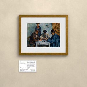 May include: A framed art print of Paul C&eacute;zanne's The Card Players, featuring four figures seated around a table playing cards. The painting is housed in a gold-toned frame and accompanied by a small informational card with text.