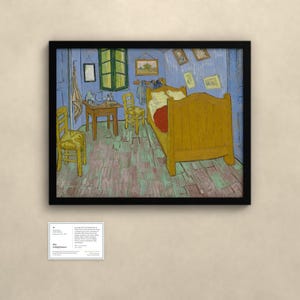May include: A framed print of Vincent van Gogh's Bedroom in Arles painting, featuring a yellow bed, two wooden chairs, a small table, and blue walls, displayed with an informational placard below it on a neutral wall.