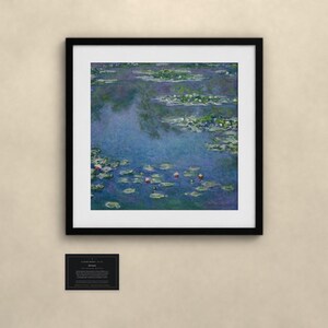 Puede incluir: Una impresi&oacute;n art&iacute;stica cuadrada enmarcada que muestra una pintura impresionista de un estanque con agua azul, nen&uacute;fares verdes y peque&ntilde;as flores de loto rosas. Debajo de la obra enmarcada hay una peque&ntilde;a placa negra con texto blanco.