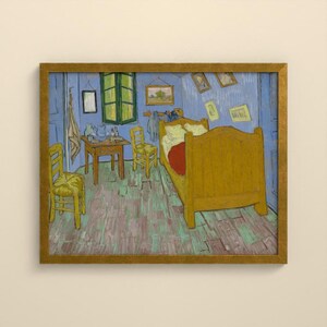 May include: A framed print of a painting depicting a bedroom with a large yellow wooden bed, two yellow chairs, a wooden table, and blue walls. Several small framed pictures hang on the walls, and a cloth hangs near a green window frame.