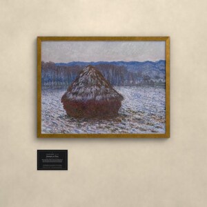 May include: A framed painting of a dark brown haystack in a snowy field under a pale sky, with blue hills in the distance. Below the frame is a small black plaque with white text reading CLAUDE MONET, Meules en Hiver, 1891, Oil on canvas.