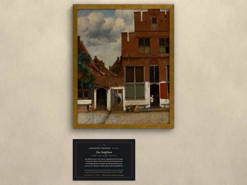 Op de afbeelding: Een ingelijste kunstdruk van Johannes Vermeer's schilderij Het Straatje, met een rood bakstenen huis met trapgevel, een geplaveide binnenplaats en figuren, vergezeld van een zwart informatiebordje met witte tekst.