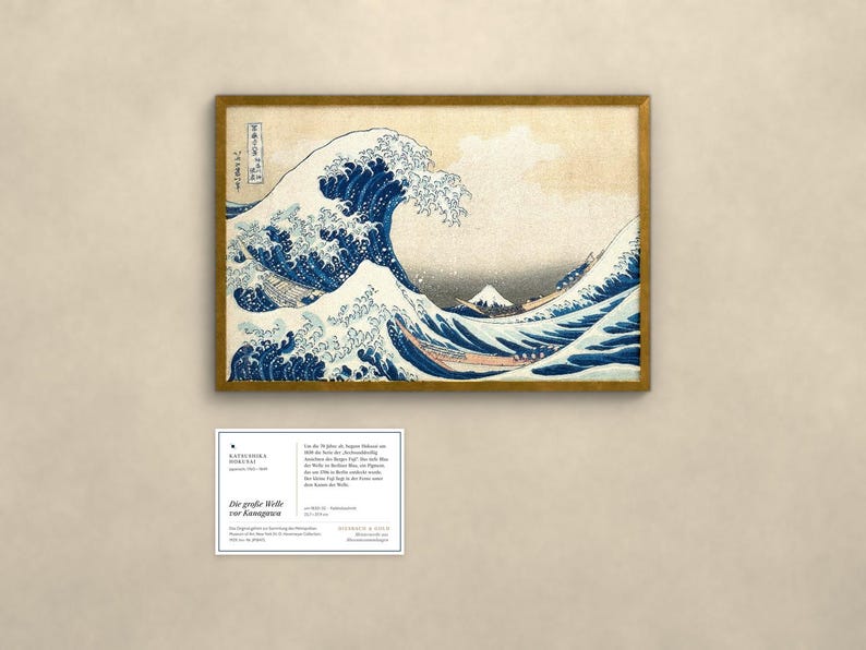 May include: A framed print of The Great Wave off Kanagawa featuring a large blue wave, white foam, and Mount Fuji in the background. Below the print is a rectangular information card with black text detailing the artwork's history.