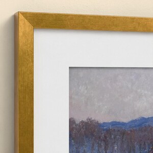 May include: A framed landscape painting featuring a textured gray sky above a line of dark blue and purple trees, set within a wide white mat and a metallic gold frame. The artwork displays visible brushstrokes and a muted color palette.