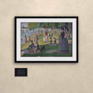 Puede incluir: Una l&aacute;mina enmarcada de Tarde de domingo en la isla de la Grande Jatte de Georges Seurat, con figuras puntillistas en un parque junto al r&iacute;o y una peque&ntilde;a placa negra con texto descriptivo debajo de la obra.