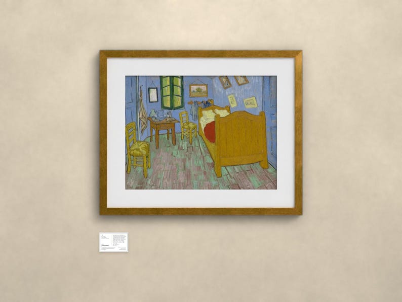 May include: A framed print of Vincent van Gogh's Bedroom in Arles painting, featuring a yellow bed, two wooden chairs, and a small table inside a blue-walled room with a green window, displayed in a gold frame with a white mat and a small label.