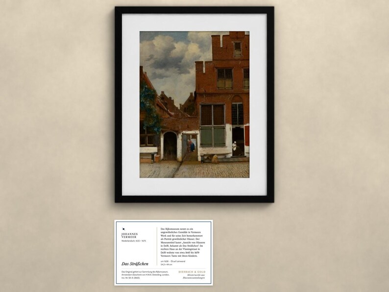 May include: A framed print of Johannes Vermeer's painting The Little Street, depicting a red brick house with a cobblestone alleyway under a cloudy sky. Below the frame is an informational card with text about the artwork and artist.