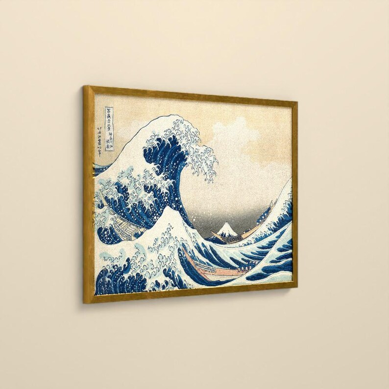 May include: A framed print of The Great Wave off Kanagawa featuring a large, cresting blue wave with white foam, small boats, and a distant Mount Fuji against a beige background. The artwork includes vertical Japanese text on the left side.