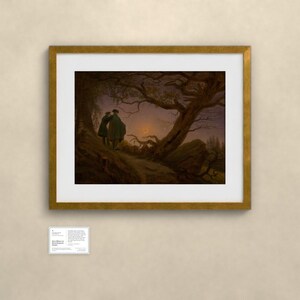 May include: A framed art print featuring a dark, atmospheric landscape painting of two figures standing on a hill under a crescent moon, framed in a gold-toned border with a white mat, accompanied by a small informational placard below.