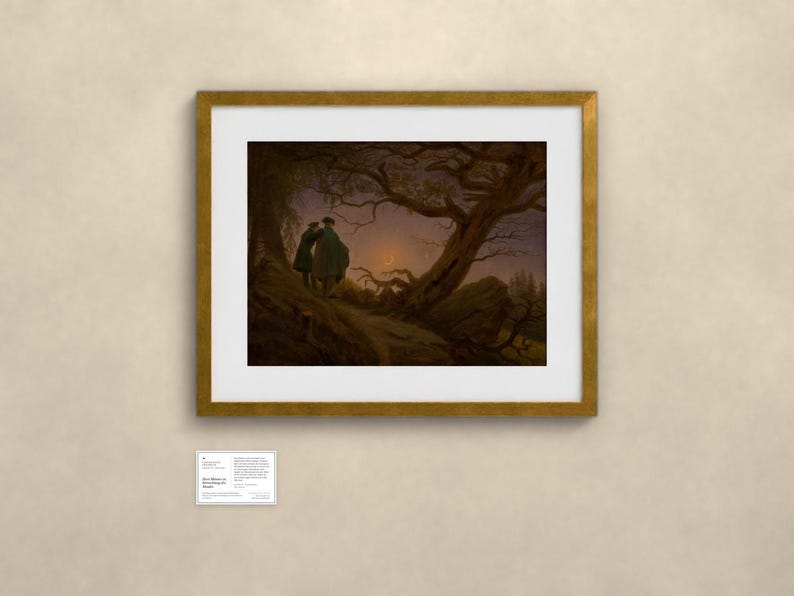 May include: A framed art print featuring a dark, atmospheric landscape painting of two figures standing on a hill under a crescent moon, framed in a gold-toned border with a white mat, accompanied by a small informational placard below.