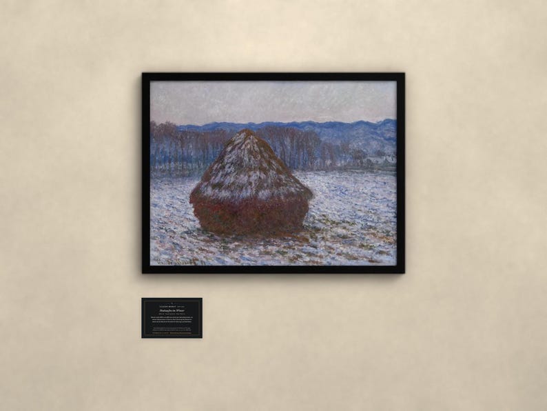 May include: A framed landscape painting depicting a large, dark brown haystack centered in a snow-covered field. In the background, a line of trees and distant blue mountains are visible under a pale sky. A small informational plaque is below the frame.