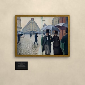 May include: A framed oil painting depicting a rainy Paris street scene with cobblestones, featuring figures in formal 19th-century attire holding umbrellas. A couple walks in the foreground under a large umbrella, with buildings and a street lamp visible.