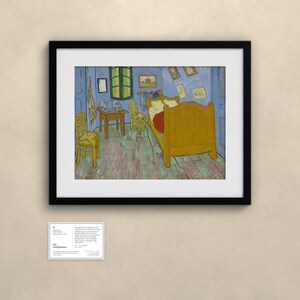 Pu&ograve; includere: Una stampa d'arte incorniciata della Camera di Van Gogh ad Arles, raffigurante un letto giallo, due sedie e un tavolino in una stanza dalle pareti blu con una finestra verde, accompagnata da un piccolo cartellino informativo con del testo.