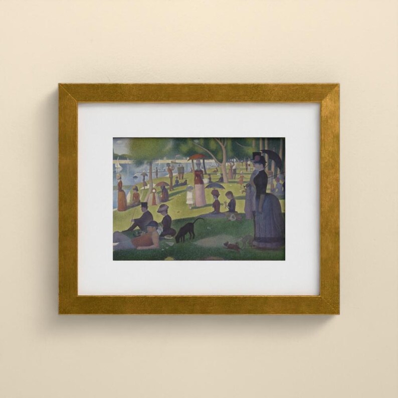 May include: A framed print of Georges Seurat's A Sunday Afternoon on the Island of La Grande Jatte, featuring a park scene with figures, trees, and a river, enclosed in a textured gold frame with a wide white mat border.