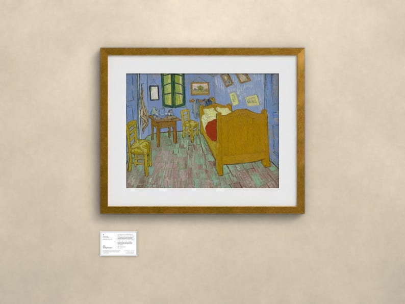 May include: A framed print of Vincent van Gogh's Bedroom in Arles painting, featuring a yellow bed, two yellow chairs, and a wooden table inside a blue-walled room with a green window, displayed in a gold-toned frame with a white mat board.