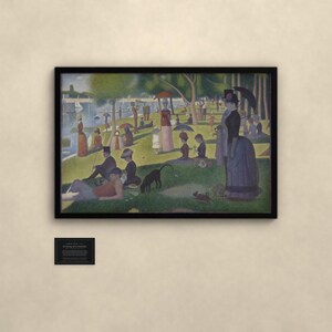 May include: A framed print of Georges Seurat's A Sunday Afternoon on the Island of La Grande Jatte, featuring a park scene with figures, umbrellas, and a dog. A small black informational plaque is mounted on the wall below the framed artwork.
