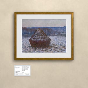 K&ouml;nnte beinhalten: Ein gerahmter Druck eines impressionistischen Gem&auml;ldes mit einem dunkelbraunen Heuhaufen auf einem verschneiten Feld unter einem blassen Himmel. Das Kunstwerk ist in einem goldfarbenen Rahmen mit wei&szlig;em Passepartout. Darunter befindet sich ein Schild.
