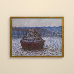 May include: A framed landscape painting featuring a large, dark brown haystack centered in a snow-covered field. The background displays a line of bare trees and distant blue mountains under a pale, overcast sky, all enclosed in a gold frame.