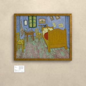 May include: A framed print of Vincent van Gogh's Bedroom in Arles painting, featuring a yellow bed, two wooden chairs, a small table, and blue walls. The artwork is displayed in a gold frame with a small white informational plaque below it.