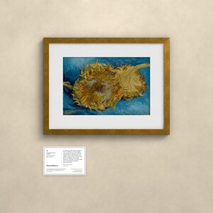 May include: A framed art print featuring two yellow sunflowers against a textured blue background, displayed with a white mat. Below the frame is a small white informational card with black text detailing the artwork's history and origin.